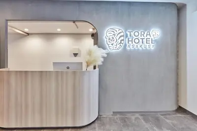 a reception area in a hotel lobby with a sign at Tora Hotel Asakusa in Tokyo