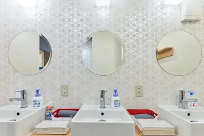 a bathroom with two sinks and two mirrors at Tora Hotel Asakusa in Tokyo