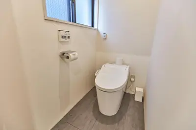 a small bathroom with a toilet with a window at Tora Hotel Asakusa in Tokyo