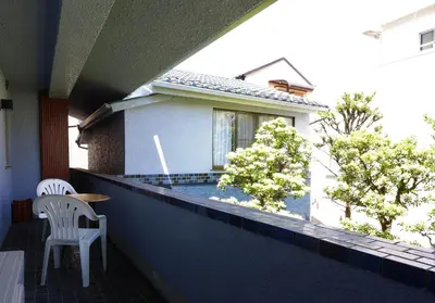 a balcony with a table and a chair and a house at Oyado Tsuki to Kawa in Tokyo