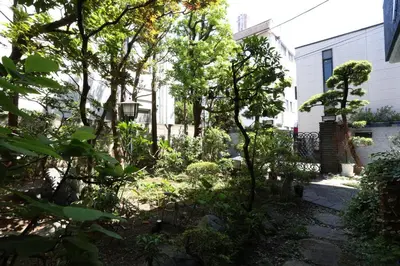 a garden in front of a house with trees at Oyado Tsuki to Kawa in Tokyo