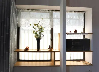 a window with a vase of flowers on a shelf at Oyado Tsuki to Kawa in Tokyo