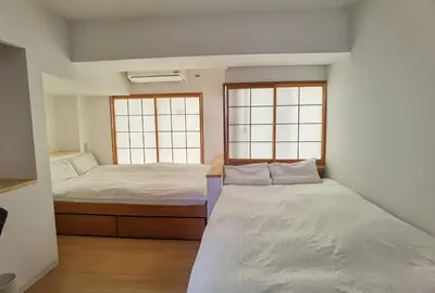 a bedroom with two beds and two windows at Hostel Belle Via Tokyo in Tokyo