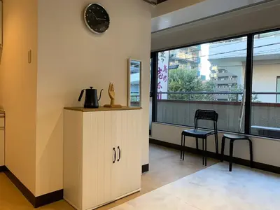 a kitchen with a counter and a chair and a clock at Spacious studio(62m2) in western Shinjuku in Tokyo