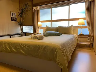 a bedroom with a large bed with two towels on it at North Shinjuku house 5\u99c5\u5f92\u6b69\u570f\u5185\u306e\u5317\u65b0\u5bbf\u306e\u5bb6 in Tokyo