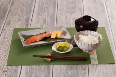a plate of sushi and a bowl of rice and chopsticks at \u30db\u30c6\u30ebDEN in Tokyo