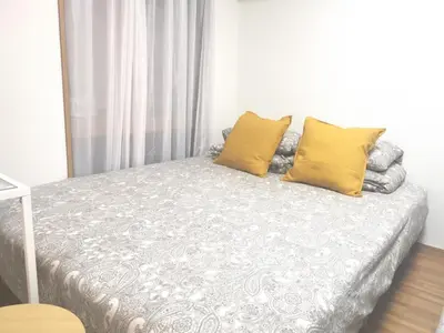 a bedroom with a bed with yellow pillows at HouseKL in Tokyo