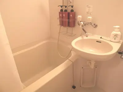 a bathroom with a sink and a bath tub at HouseKL in Tokyo
