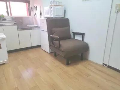 a chair sitting in a kitchen with a microwave at HouseKL in Tokyo