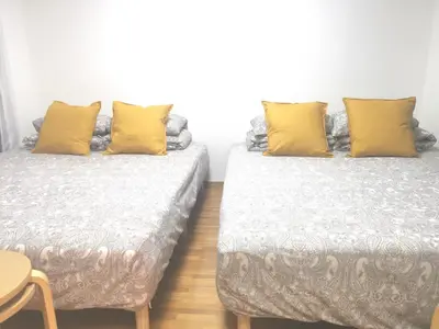 two beds in a room with yellow pillows at HouseKL in Tokyo