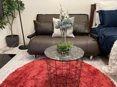 a living room with a couch and a glass table with flowers at BEST LOCATED SHINJUKU CENTRAL Full-Furnished APARTMENT 3minWalk to Station1 in Tokyo