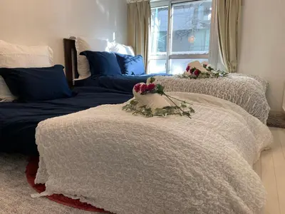 two beds with flowers on them in a bedroom at BEST LOCATED SHINJUKU CENTRAL Full-Furnished APARTMENT 3minWalk to Station1 in Tokyo