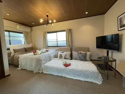 a bedroom with two beds and a flat screen tv at Best Shinjuku Modern Full-furnished Family size Apartment3 ONLY 2min to Shinjuku by Train in Tokyo