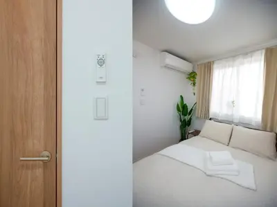 a bedroom with a white bed and a window at Skytree Cozy House in Tokyo