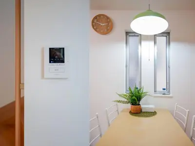 a dining room with a table and a clock on the wall at Skytree Cozy House in Tokyo