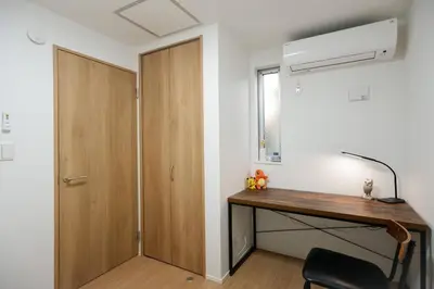 a room with a wooden desk and a door at Skytree Cozy House in Tokyo