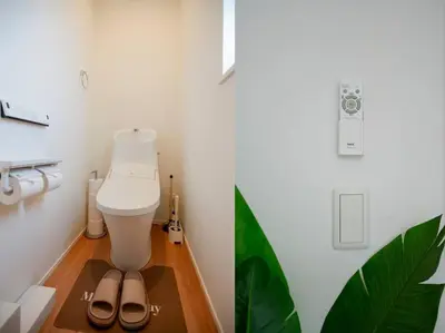 a bathroom with a toilet and a pair of sandals on the floor at Skytree Cozy House in Tokyo