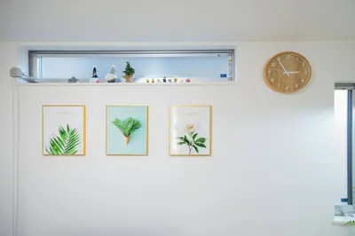 a row of framed photos on a wall with a clock at Skytree Cozy House in Tokyo