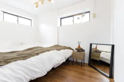 a white bedroom with a large bed and a mirror at CentralTokyo・Shinjuku/ 4BedRooms/8Beds / old style in Tokyo