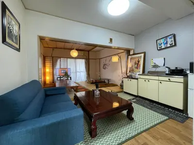 a living room with a blue couch and a table at Shinjuku Shin-Okubo Station Nippon no Yado in Tokyo