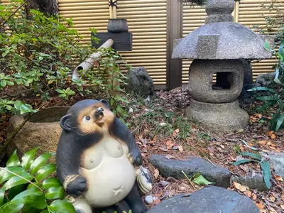 a statue of a monkey sitting next to a bird house at Shinjuku Shin-Okubo Station Nippon no Yado in Tokyo