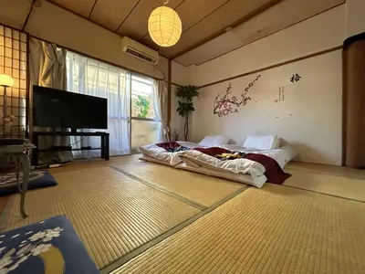 a living room with a bed and a flat screen tv at Shinjuku Shin-Okubo Station Nippon no Yado in Tokyo
