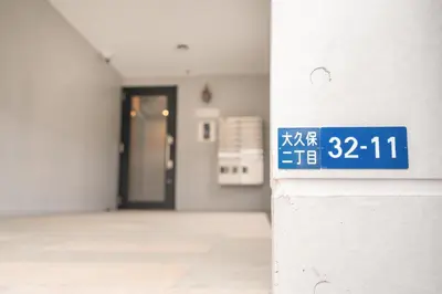 an empty hallway with a blue sign on a wall at Real Okubo Apartment Hotel in Tokyo