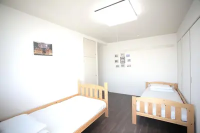 two beds in a room with white walls at \u30b2\u30b9\u30c8\u30cf\u30a6\u30b9\u6634 in Tokyo