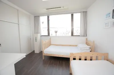 a bedroom with two beds and a window at \u30b2\u30b9\u30c8\u30cf\u30a6\u30b9\u6634 in Tokyo