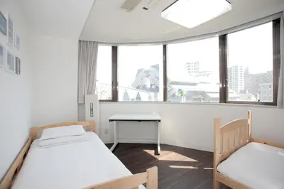 a room with two beds and a desk and windows at \u30b2\u30b9\u30c8\u30cf\u30a6\u30b9\u6634 in Tokyo