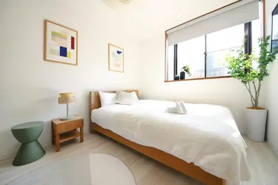 a white bedroom with a bed and a window at Pirane House 201 \u6771\u4eac\u30b9\u30ab\u30a4\u30c4\u30ea\u30fc\u6d45\u8349 \u62bc\u4e0a\u99c5\u304c\u5f92\u6b69\u570f\u5185 \u7121\u6599wifi in Tokyo