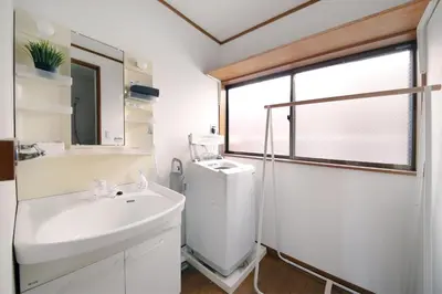 a white bathroom with a sink and a shower at Pirane House 201 \u6771\u4eac\u30b9\u30ab\u30a4\u30c4\u30ea\u30fc\u6d45\u8349 \u62bc\u4e0a\u99c5\u304c\u5f92\u6b69\u570f\u5185 \u7121\u6599wifi in Tokyo