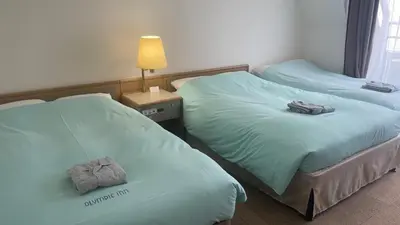 two beds in a hotel room with towels on them at Olympic Inn Kanda in Tokyo