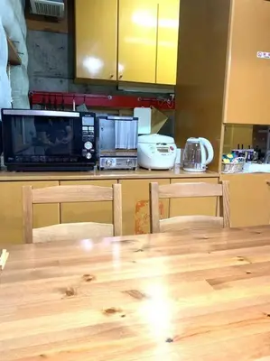 a kitchen with a wooden table and a microwave at Ikebukuro sta. 10mins walk. Rough style 88\u33a1 House in Tokyo