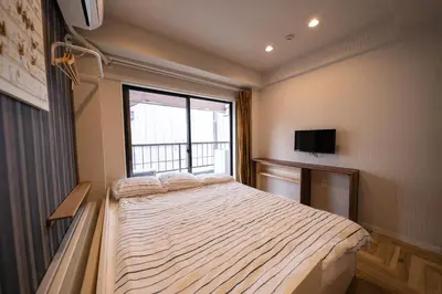 a bedroom with a large bed and a window at \u6c60\u888bC1\u51fa\u53e3\u5f92\u6b695\u5206\u30002LDK \u307e\u308b\u307e\u308b\u8cb8\u5207\u3000\u885b\u751f\u8a2d\u5099\u5145\u5b9f in Tokyo