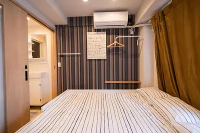 a bedroom with a bed in a room at \u6c60\u888bC1\u51fa\u53e3\u5f92\u6b695\u5206\u30002LDK \u307e\u308b\u307e\u308b\u8cb8\u5207\u3000\u885b\u751f\u8a2d\u5099\u5145\u5b9f in Tokyo
