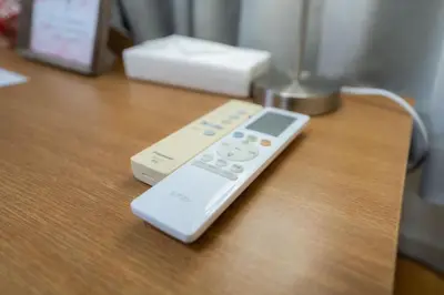 a remote control sitting on top of a wooden table at Budget 3-Bedrooms Villa#4mins to Ikebukuro#Hight speed wifi#Near Train Tracks in Tokyo