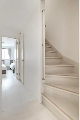 a staircase in a house with white walls and wooden floors at SKYTREE HOUSE in Tokyo