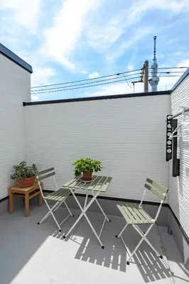 a patio with two chairs and a table and a fence at SKYTREE HOUSE in Tokyo