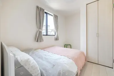 a white bedroom with a bed and a window at SKYTREE HOUSE in Tokyo