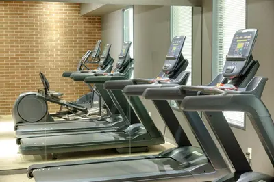 a row of treadmills in a gym with mirrors at Tosei Hotel Cocone Tsukiji Ginza Premier in Tokyo