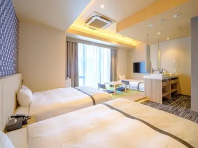 a hotel room with two beds and a television at Tosei Hotel Cocone Tsukiji Ginza Premier in Tokyo