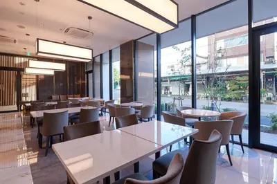 a restaurant with tables and chairs and large windows at Tosei Hotel Cocone Tsukiji Ginza Premier in Tokyo