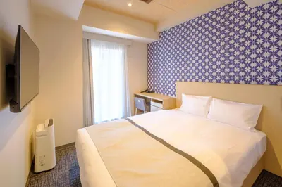 a bedroom with a white bed and a blue wall at Tosei Hotel Cocone Tsukiji Ginza Premier in Tokyo