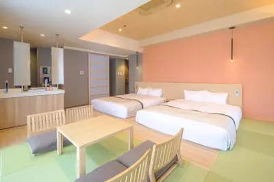 a bedroom with two beds and a table and a kitchen at Tosei Hotel Cocone Tsukiji Ginza Premier in Tokyo