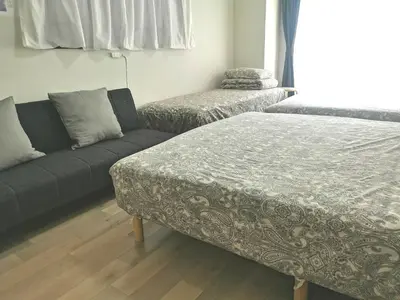 a room with a bed and a couch and a window at B Shinjuku Self Check in in Tokyo
