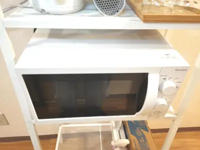 a microwave on a shelf in a table at B Shinjuku Self Check in in Tokyo