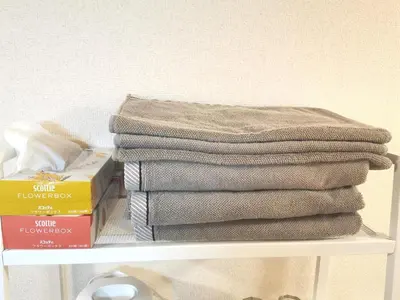 a pile of towels sitting on top of a shelf at B Shinjuku Self Check in in Tokyo