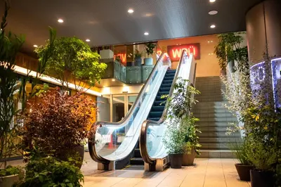 an escalator in a mall with a slide at WPÜ HOTEL Shinjuku in Tokyo