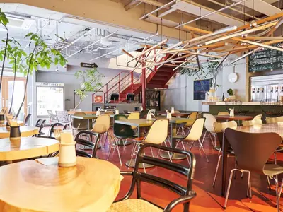 a restaurant with tables and chairs and a staircase at WPÜ HOTEL Shinjuku in Tokyo